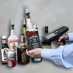 man scanning the barcode of a Jack Daniels bottle while setting up a bar inventory system