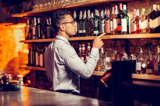 bartender counting inventory behind the bar