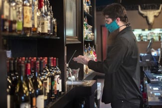 bartender wearing a mask and washing hands to protect against COVID-19