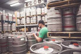 bartender taking inventory of beer kegs