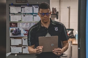 bar manager counting inventory with a clipboard