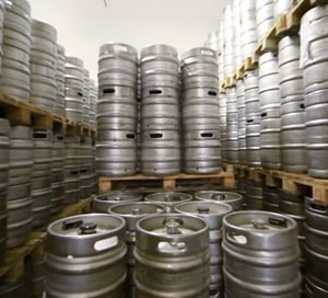 taking inventory of beer kegs in a crowded storeroom