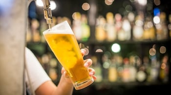 draft beer being poured behind a bar