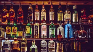 liquor bottles arranged behind the bar so that similar botttles are kept together