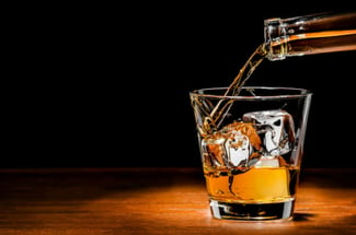 pouring whiskey on the rocks at a high-end bar