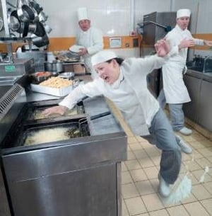 woman slipping and suffering a workplace injury in a restaurant kitchen